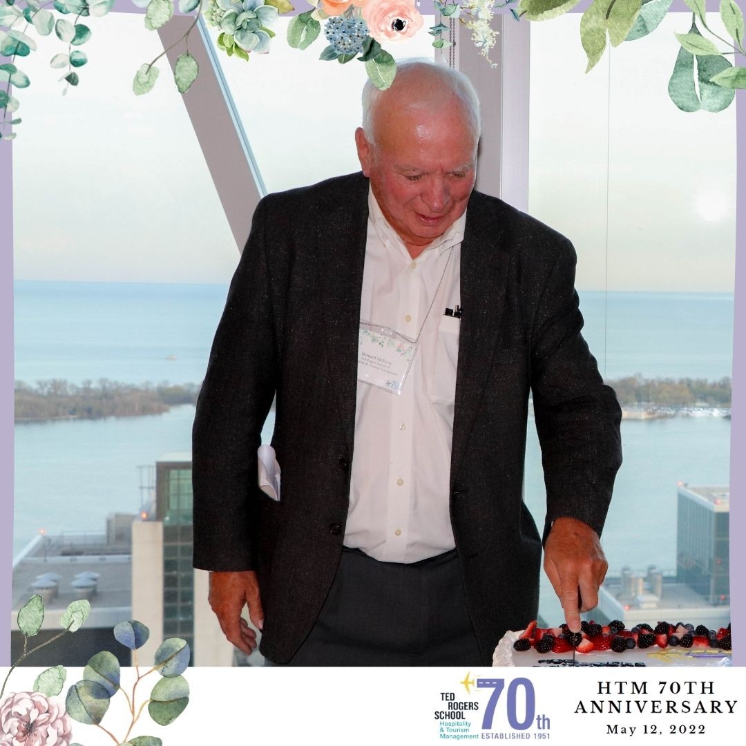 A man looking down and cutting cake at HTM's 70th annivesary party.